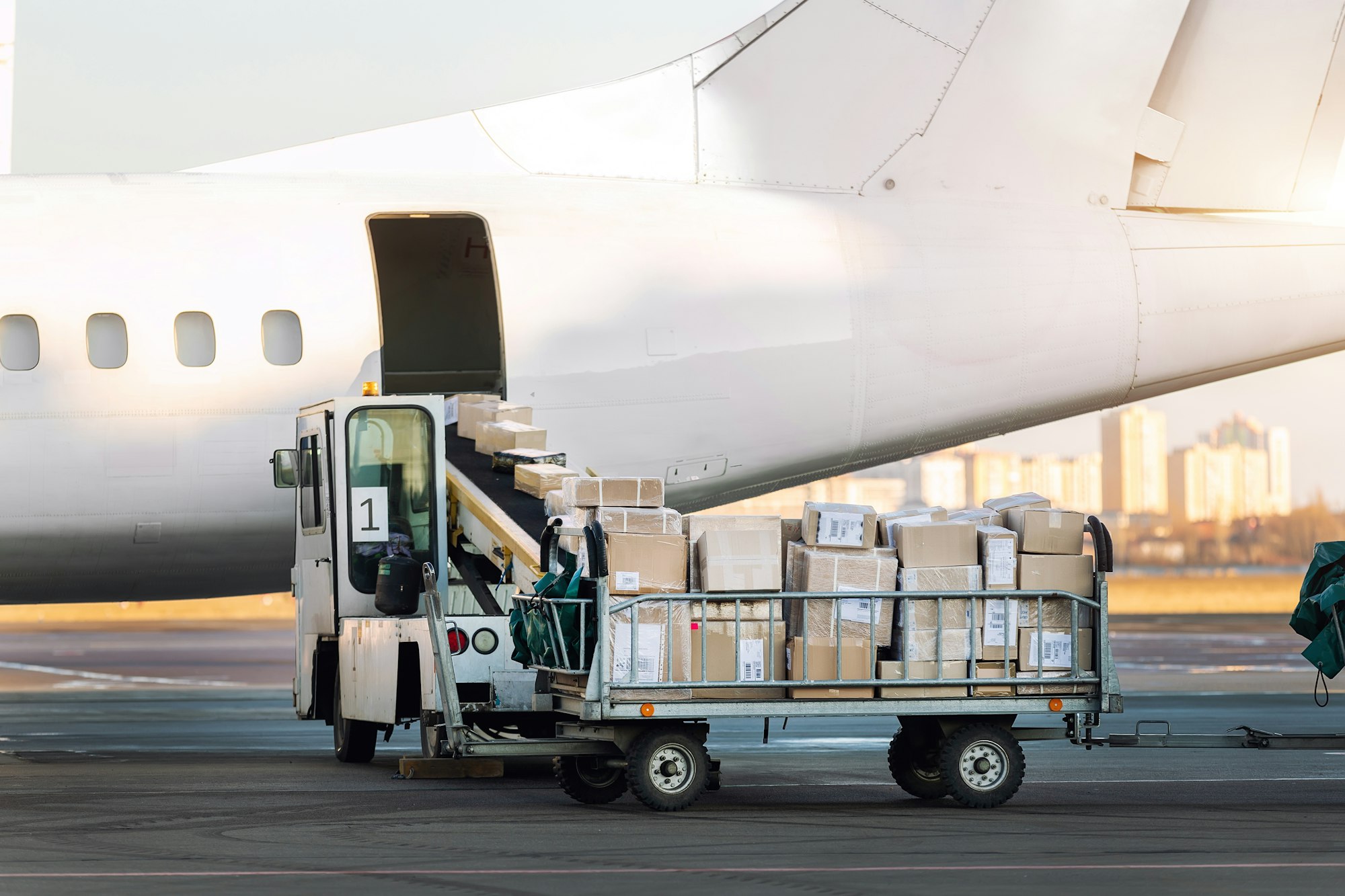 Close-up detail view of cargo cart trolley full with commercial parcels against turboprop cargo