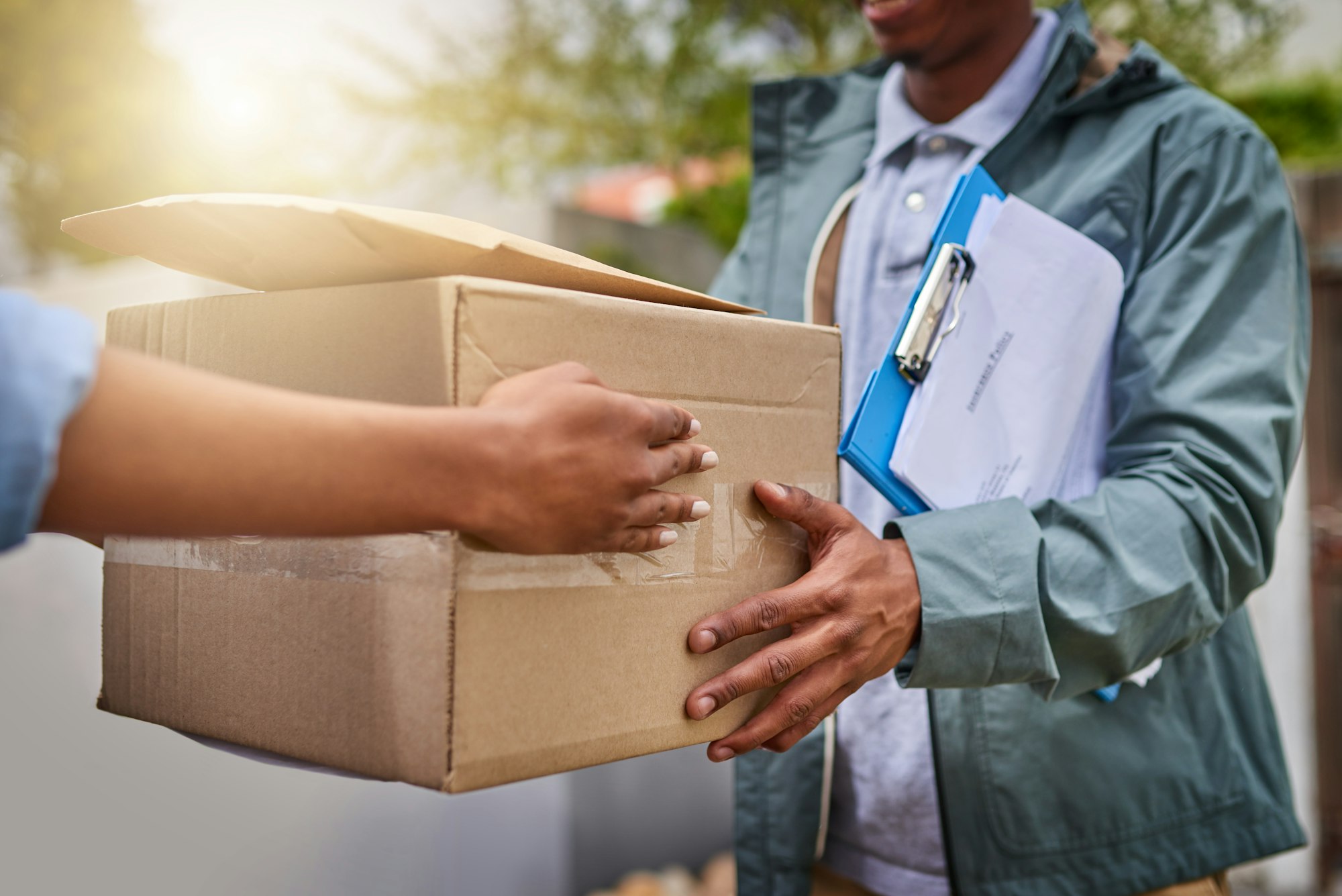 Closeup shot of an unrecognizable courier making a delivery to a customer